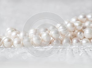 Nature white string of pearls on a sparkling background in soft focus, with highlights