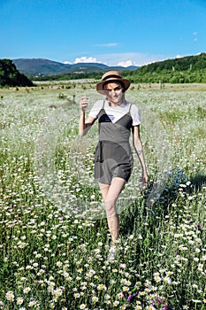 in nature a woman in a straw hat in a field with daisies flowers