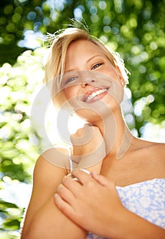 Natures beauty pales in comparison...Portrait of a beautiful young woman standing in a sunlit forest.