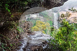 Natures window to a waterfall viewed through the cliff ledge