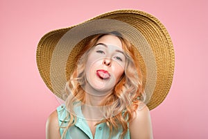 Naughtiness antics frolicking girl sunhat tongue photo