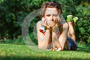 Naughty charismatic teenager in casual style on background of green grass