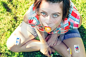 Naughty charismatic teenager in casual style on background of green grass