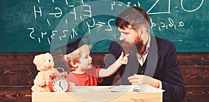 Naughty child concept. Father with beard, teacher teaches son, little boy. Kid cheerful distracting while studying