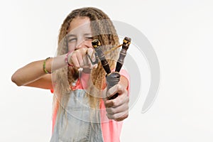 Naughty girl teenager with curly hair holds a slingshot.