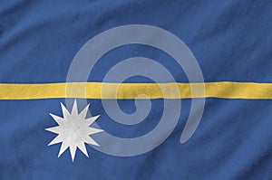 Nauru flag depicted on folded wavy fabric of old cloth photo