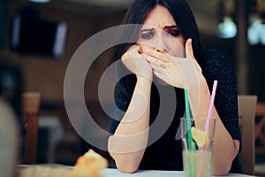 Nauseated Woman Feeling Sick at the Restaurant photo