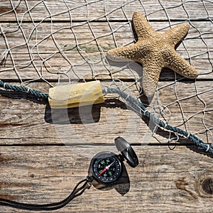 Nautical border with fishing net, sea shells and starfish on a b