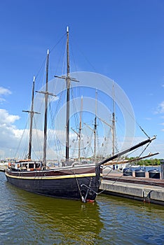 Nautical maritime scene with ropes and mast on a ship on a dock by the water