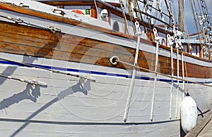 Nautical maritime scene with ropes and mast on a ship on a dock by the water