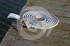 Nautical mooring rope on wooden pier