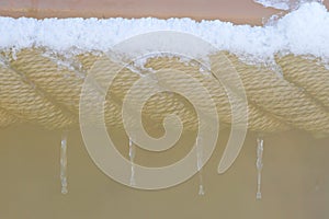 Nautical rope curving coil covered with snow and ice