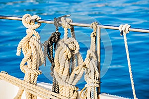 Nautical ropes knotted on railing of sailboat deck