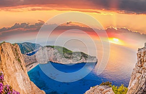 Navagio beach with shipwreck and flowers against sunset on Zakynthos island in Greece