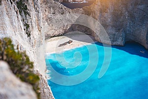 Navagio beach with turquoise blue sea water surrounded by huge white cliffs. Famous landmark location on Zakynthos