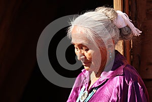 A Navajo Woman Looking Down Outdoors in Bright Sun
