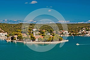 Naval storehouse and careening wharf in Mahon, Spain. Boats in sea harbor. Sea coast on sunny blue sky. Summer vacation