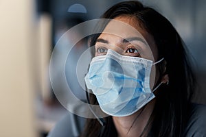 Navigating a new world of customer relationship management. a masked young woman using a headset and computer late at