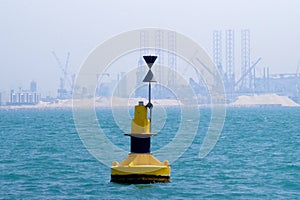 Navigation buoy at the entrance of a channel. Oil and gas marine industry as a background: Jack-ups, rigs...