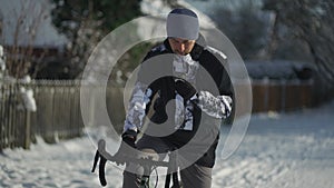 Navigation, GPS positioning, routing, offline map in a smartphone. Male cyclist stopped while cycling in winter in snow