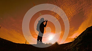 Navigation travel silhouette concept. Man hiker traveler checking smartphone sunshine sunset the gps navigator hiking in