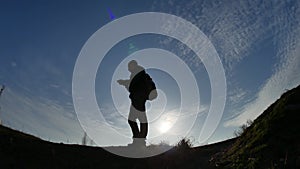 Navigation travel silhouette concept. Man hiker traveler checking smartphone sunshine sunset the gps navigator hiking in