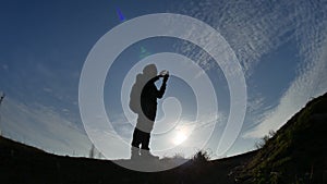 Navigation travel silhouette concept. Man hiker traveler checking smartphone sunshine sunset the gps navigator hiking in