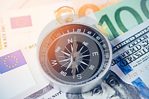 Navigational compass on money. Choice of investment strategy and capital investments.