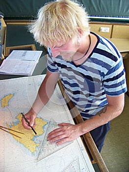 Navigational duty officer insert the position into the sea chart