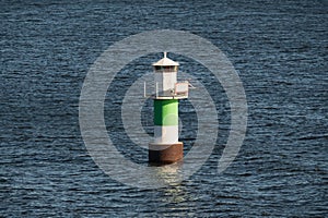 A navigational mark or lighthouse with a green stripe helps ships navigate Stockholm archipelago waters photo