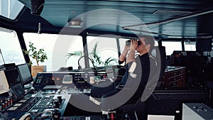 Navigational officer lookout on navigation watch looking through binoculars