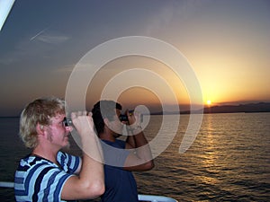 Navigational officer is watching the periphery of the anchorage with young trainee