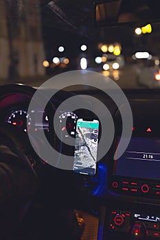 Navigator in a smartphone in a car at night, close-up.