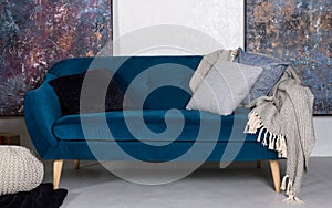 Navy blue retro sofa with cushions and gray blanket