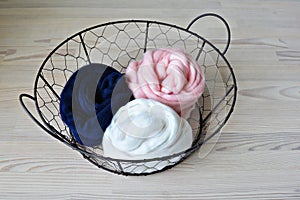 Navy, pale pink and white merino wool in round wire basket