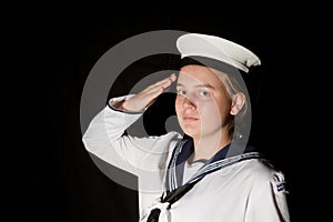 Navy seaman saluting on black