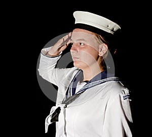 Navy seaman saluting on black