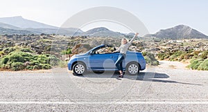 Naxos, Greece - May 2018: woman drives convertible blue car on mountain road