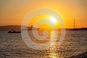 Naxos island, sunset over Aegean sea, Cyclades Greece. Sundown beams colors ships, water, sky