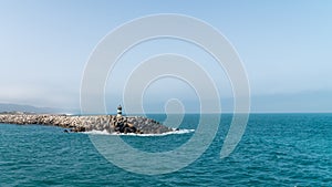 The green lighthouse of Porto de Abrigo from Nazare in Central Portugal photo