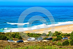 Nazare, Portugal: View of North beach and Atlantic Ocean with cars parked oposite sandy dunes