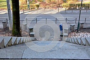 Image of concrete stone steps stairway going down to street with view of park in background