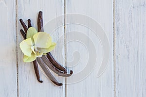 Dried vanilla pods and orchid vanilla flowers on wooden background.vanilla sugar