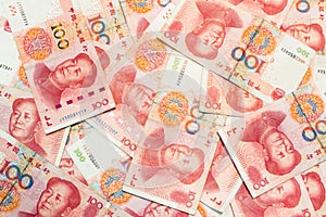 ne hundred Chinese yuan banknotes as background.