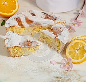 Neapolitan easter pie sprinkled with icing sugar and decorated with almond blossom and fresh fruits.