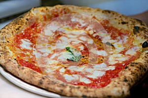 Neapolitan pizza Margherita served in a pizzeria in Napoli, Italy