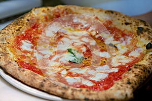 Neapolitan pizza Margherita served in a pizzeria in Napoli, Italy photo