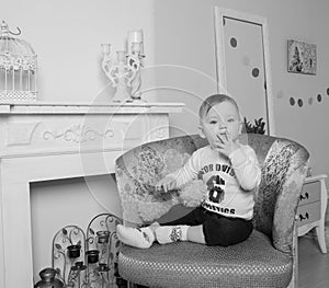 Near the fireplace in the living room, child on chair, black and White