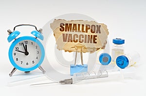 Near the stethoscope are a syringe, ampoules and a clip with a cardboard plate - smallpox vaccine