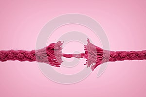 Nearly broken rope on pink background - Concept of violence against women